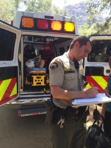 The teenage hiker sits in the ambulance and shown to have injured his right leg.