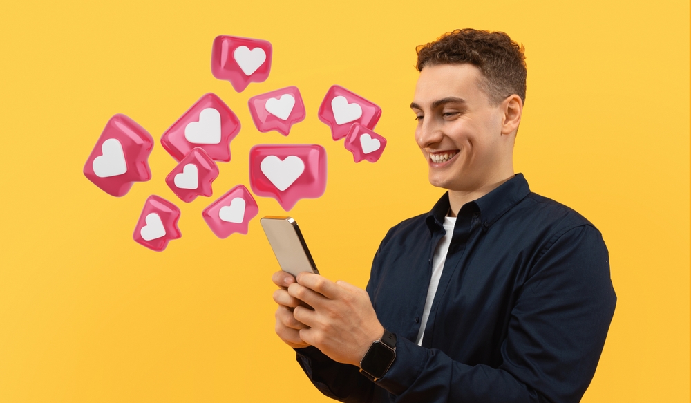 Positive,Cool,European,Guy,Using,Smartphone,Isolated,On,Yellow,Studio